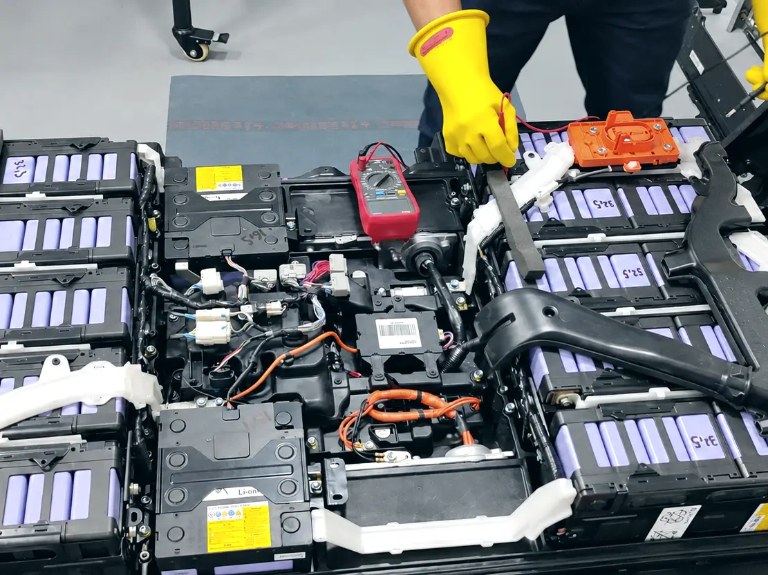 Práctica de medición con guantes dieléctricos sobre la batería de alta tensión de un vehículo eléctrico