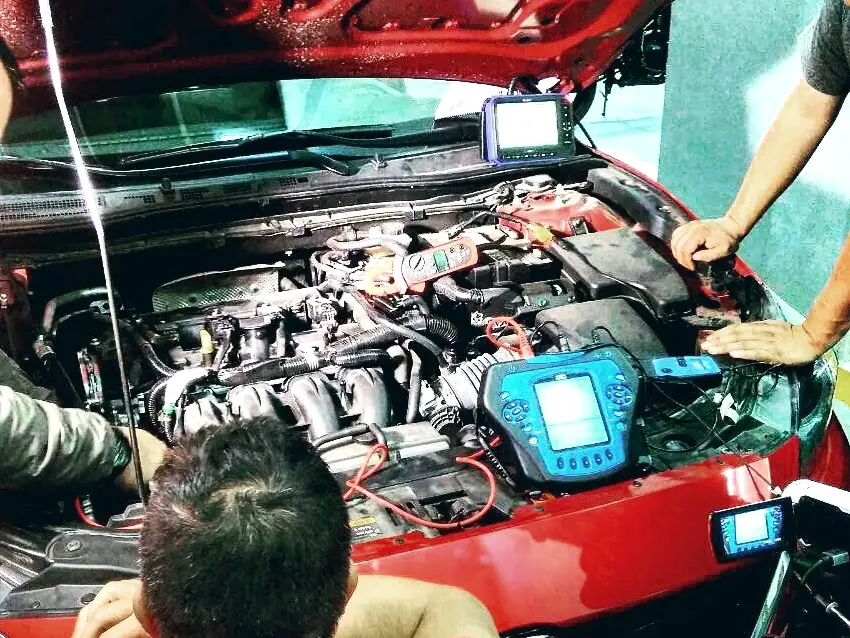 Técnicos diagnosticando un vehículo con escáner y osciloscopio
